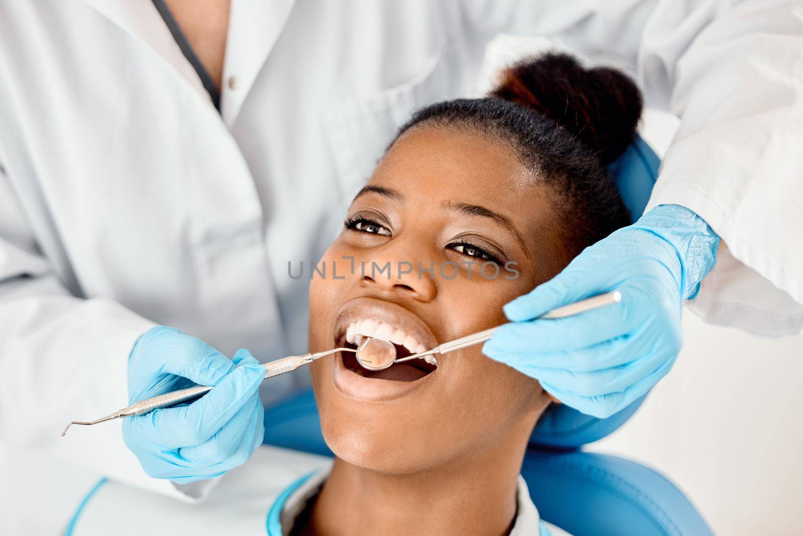 Healthy gums mean a healthy mouth. a young female patient having her teeth examined. by YuriArcurs
