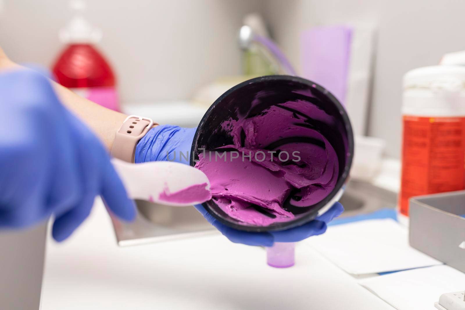 A dentist woman's hands mixing paste at the dental clinic by stockrojoverdeyazul