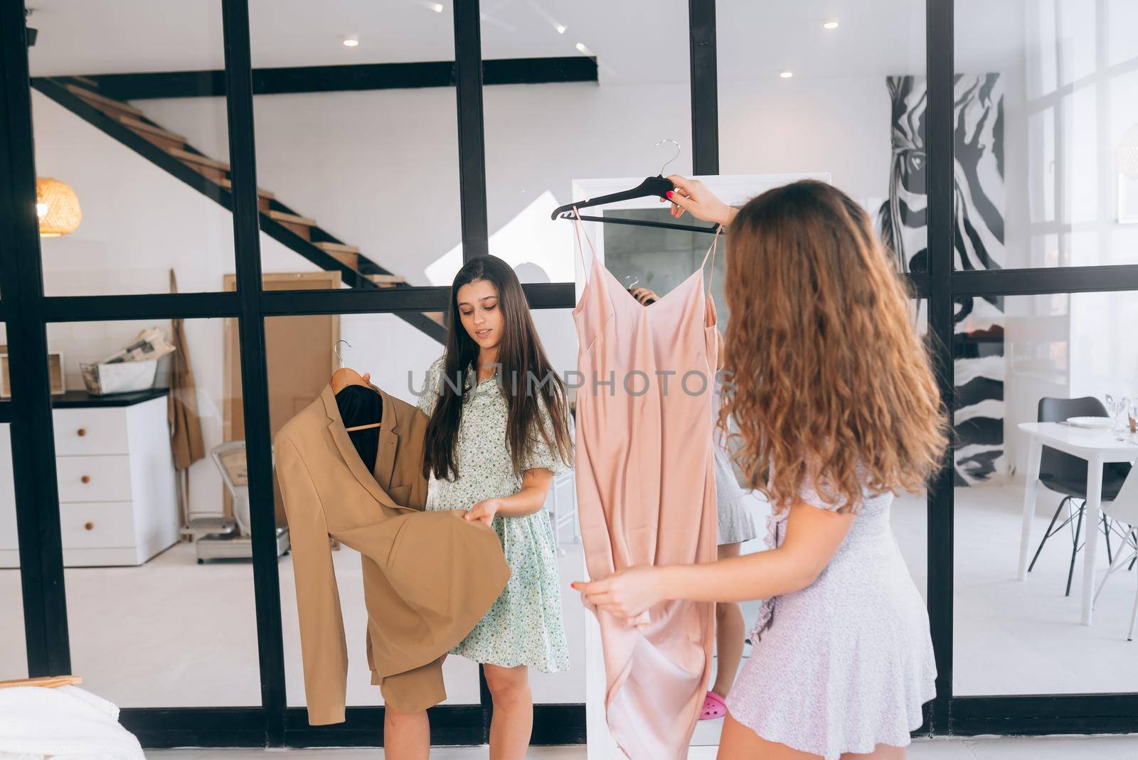 Image of pretty females trying on dress at home