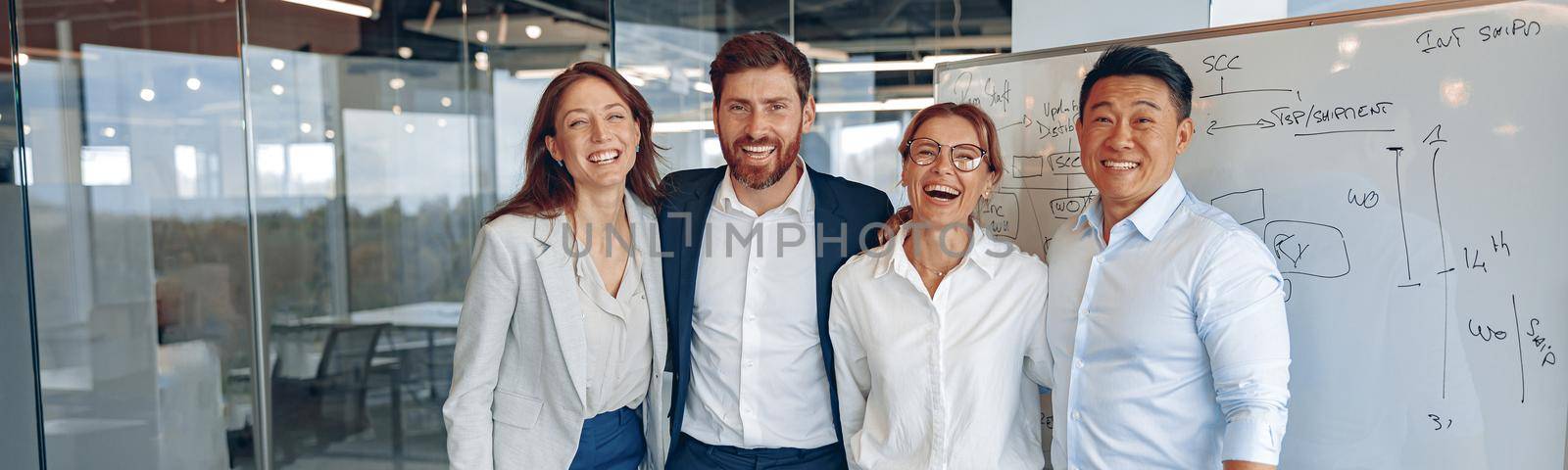 Happy diverse professional business team stand in office near board looking at camera, smiling by Yaroslav_astakhov
