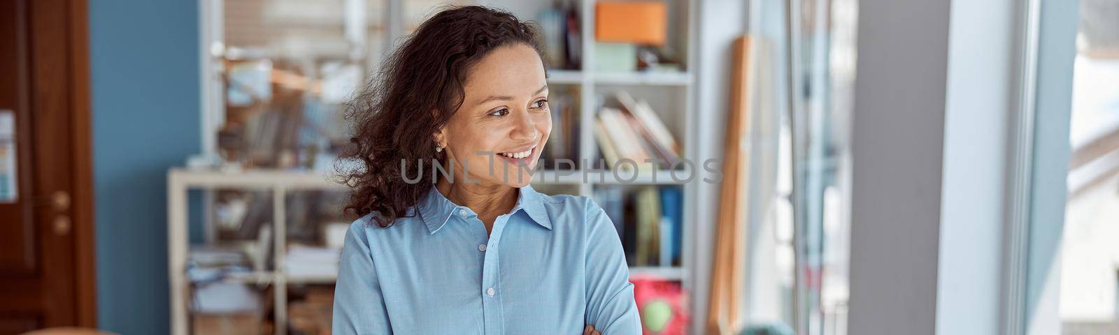 young beautiful smiling professional african american teacher portrait in school classroom by Yaroslav_astakhov