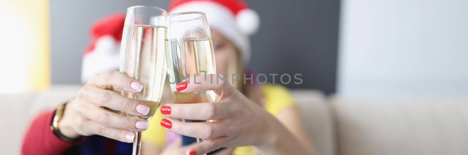 Portrait of women hold champagne drinks, glass filled with alcohol, raise toast for new year coming. Friends celebrate holiday together. Christmas concept