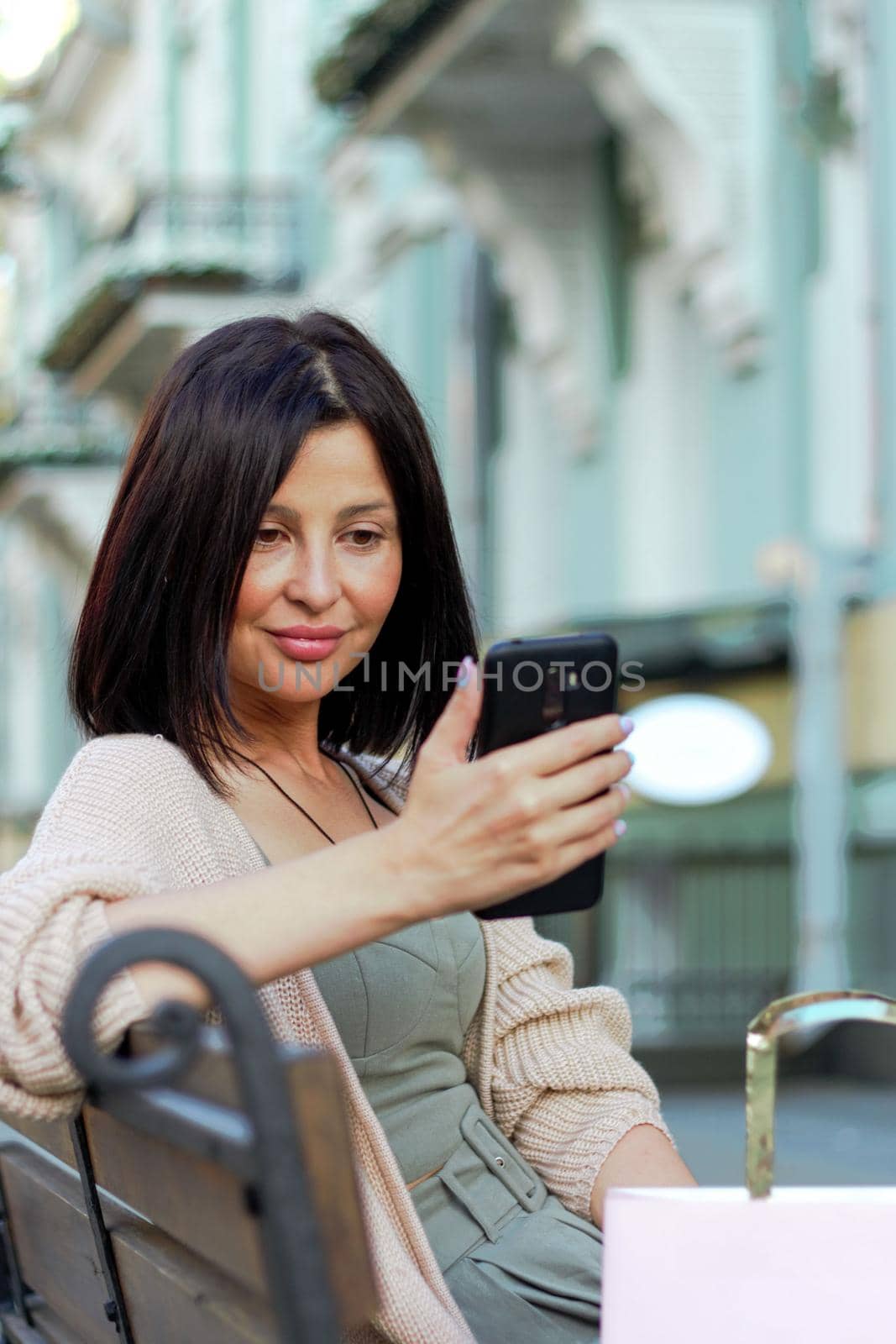 Young beautiful woman smiling going to the shops using smartphone by AleksandraLevkovskaya