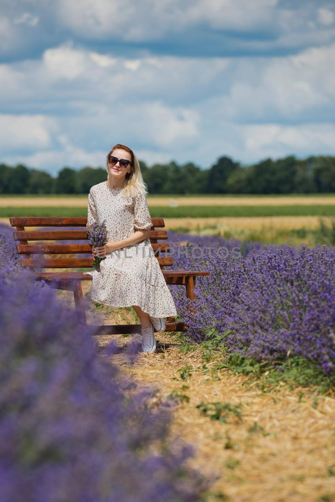 Relaxed young woman sitting in a lavender field a sunny day.