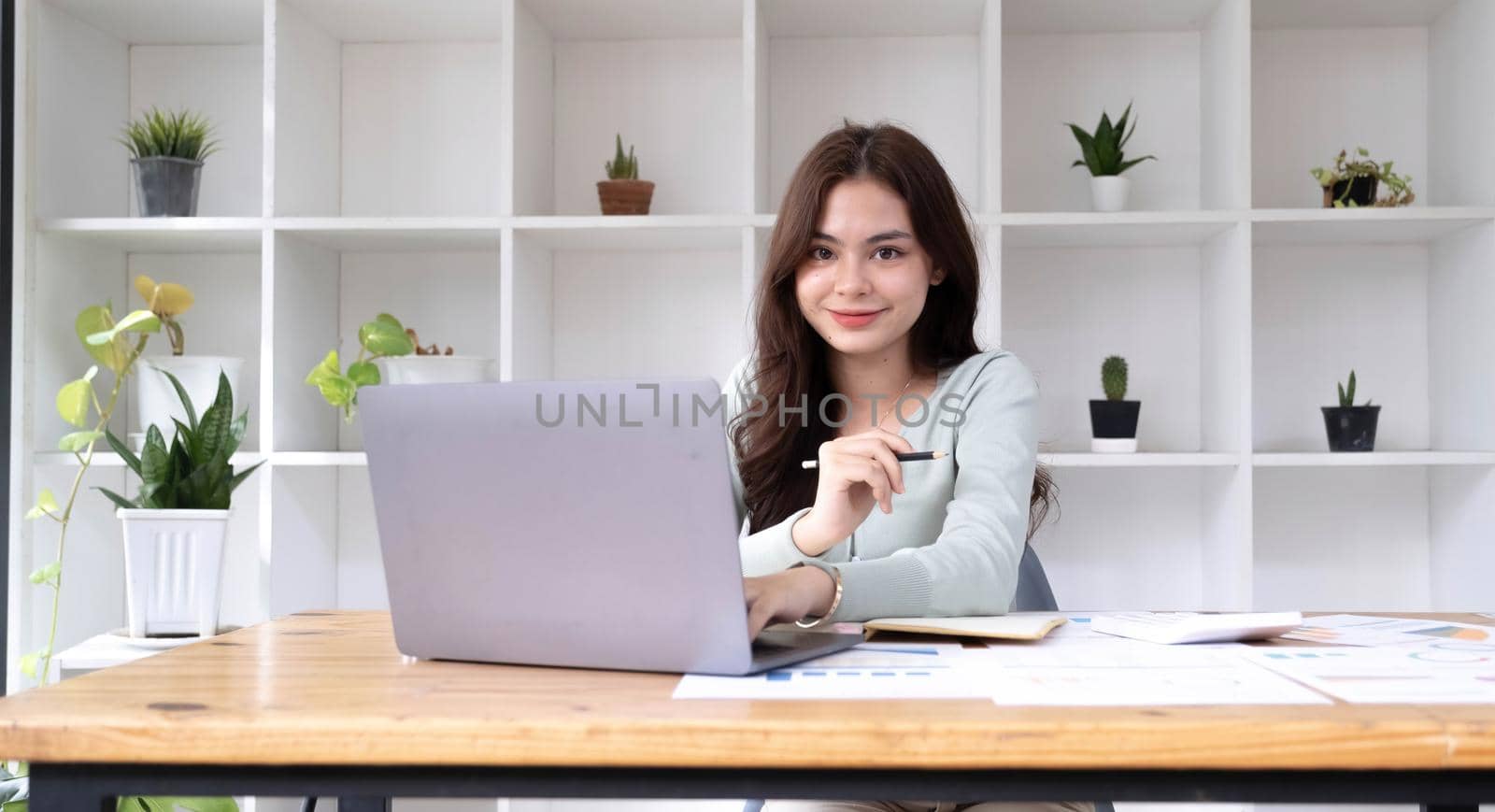 Portrait of smiling beautiful business asian woman working in modern office desk using tablet laptop computer, Business people employee freelance online marketing e-commerce telemarketing concept..