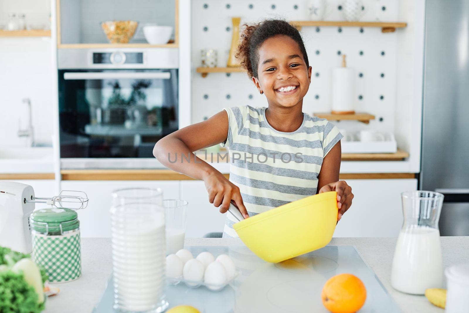 Happy little girl cooking at home