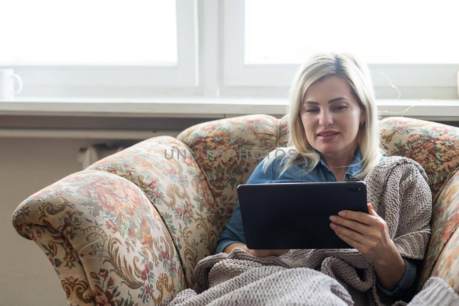 Young woman holding the tablet and sitting at home