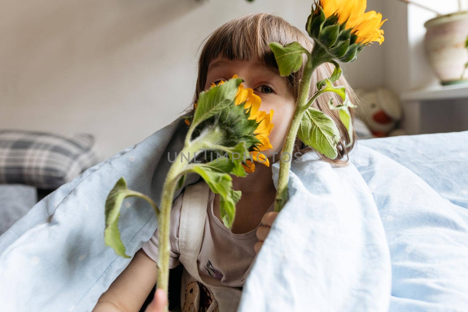 Portrait of a toddler girl holding sunflowers. High quality photo