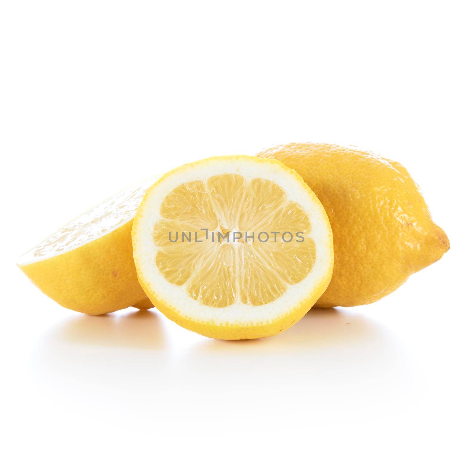 Lemons, sliced in half and whole, on a white background with shadow