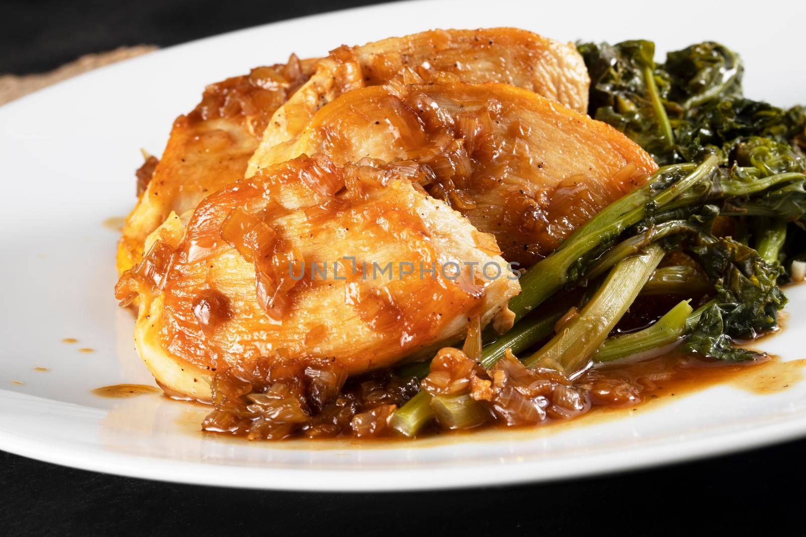 Chicken breast medallions with shallot marsala gravy, polenta and broccoli rabe, close up