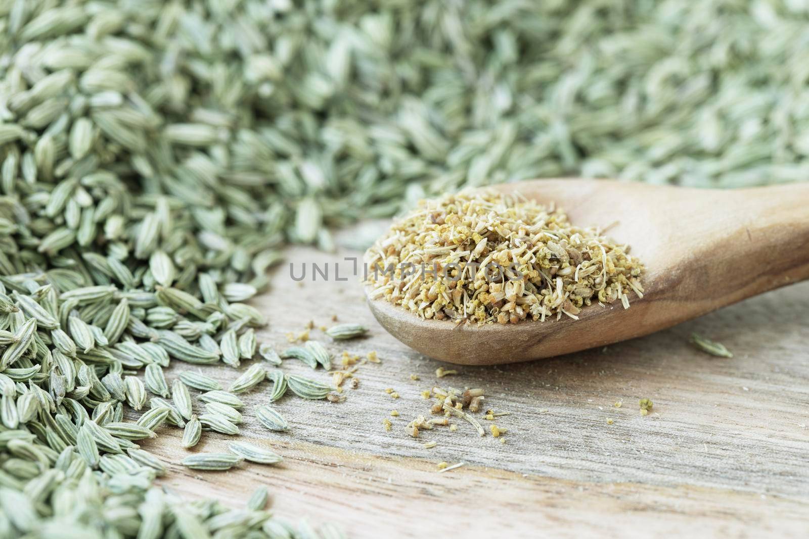 Wooden spoon with fennel pollen surrounded by fennel seeds