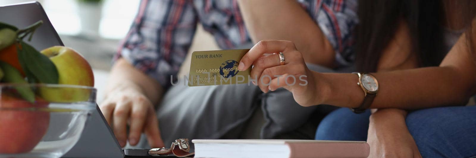 Close-up of wife and husband want to buy something online via credit card payment. Open laptop on desk and man search. Online shopping, contactless concept
