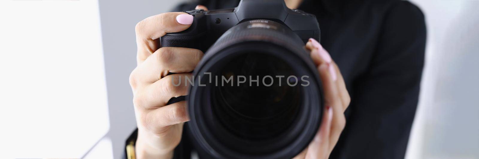 Professional woman photographer hold last model of photocamera by kuprevich