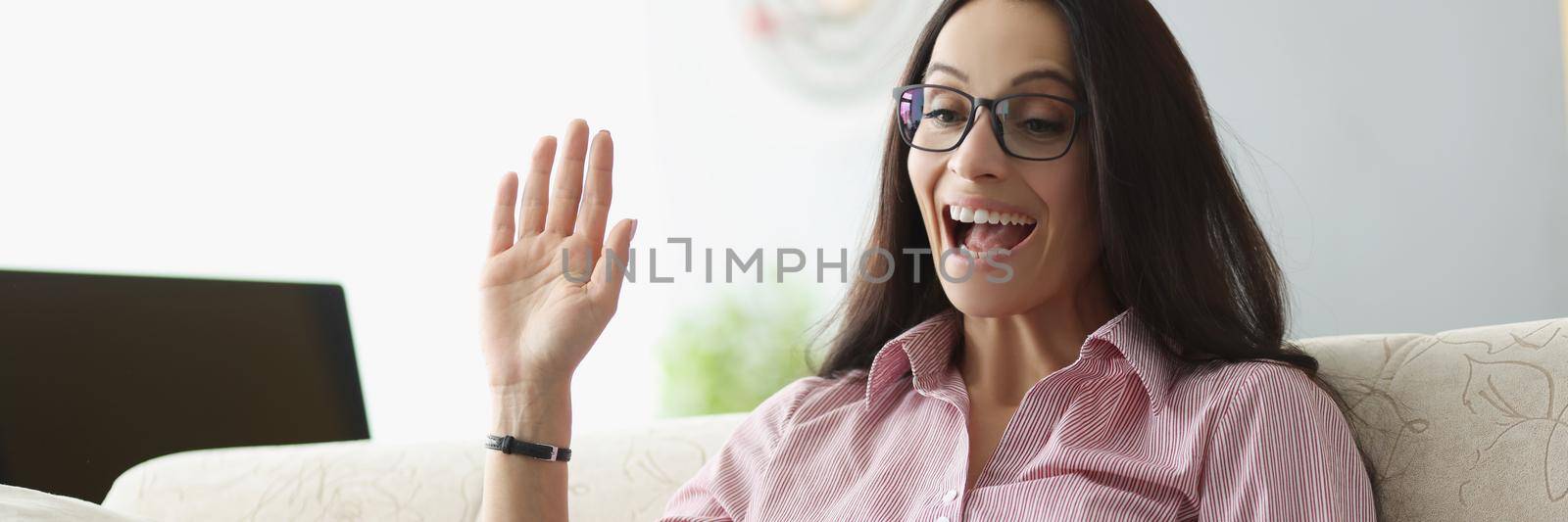 Pretty young woman wave hello show gesture online on laptop by kuprevich