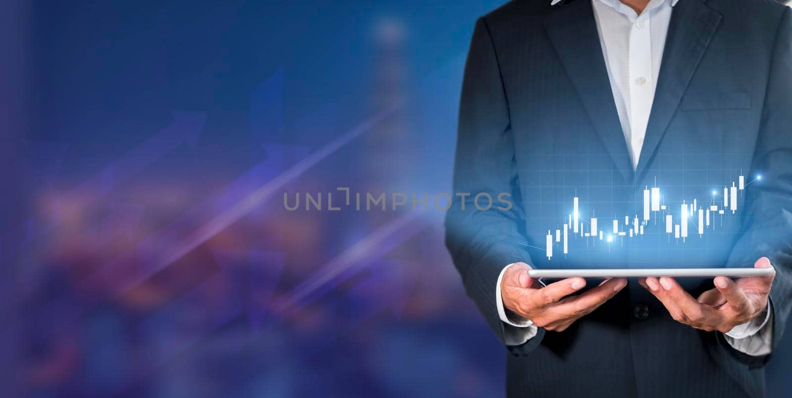 Hand of businessman holding tablet analysis stock market graph growth and increase of chart positive indicators. Hand holding tablet show stock chart on light gray background. copy space banner