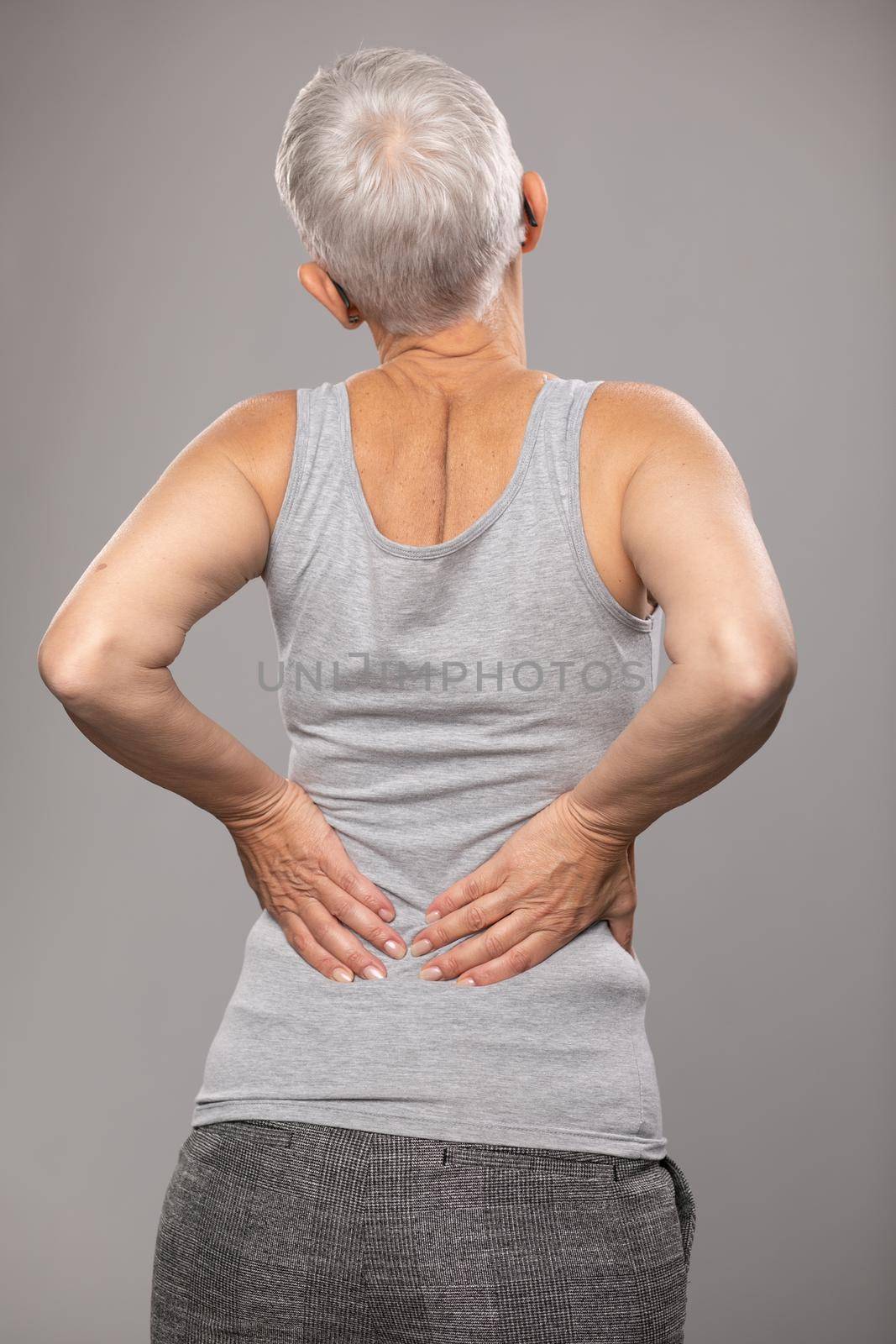 Backache pain in lower back, sciatica, senior woman with  body and muscle problems by adamr