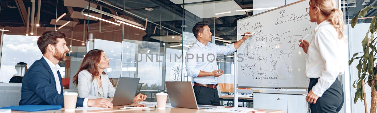 Asian man and woman conducts meeting for employees and explains the work strategy.