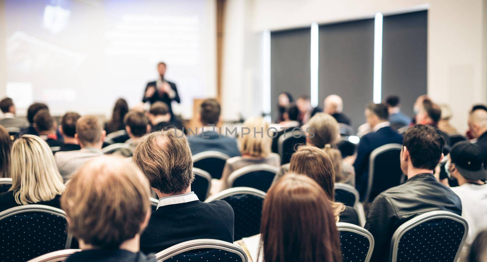 Speaker giving a talk in conference hall at business event. Rear view of unrecognizable people in audience at the conference hall. Business and entrepreneurship concept. by kasto