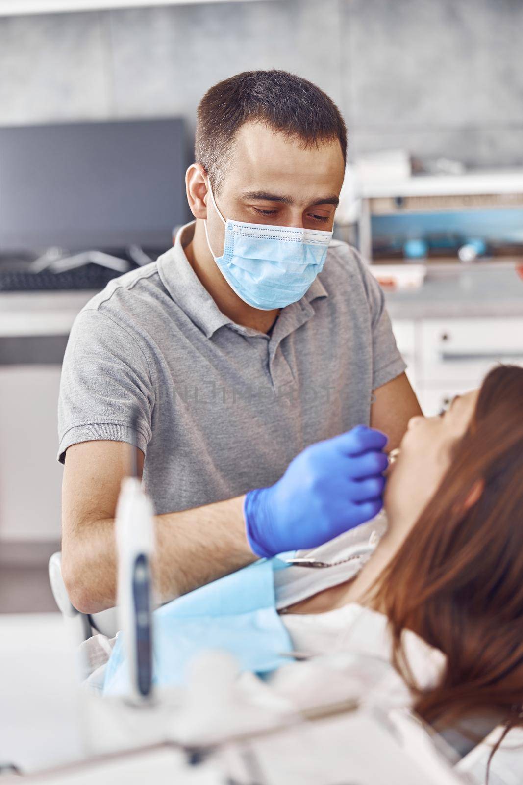 Professional doctor is choosing a colour of teeth in modern dental clinic by Yaroslav_astakhov