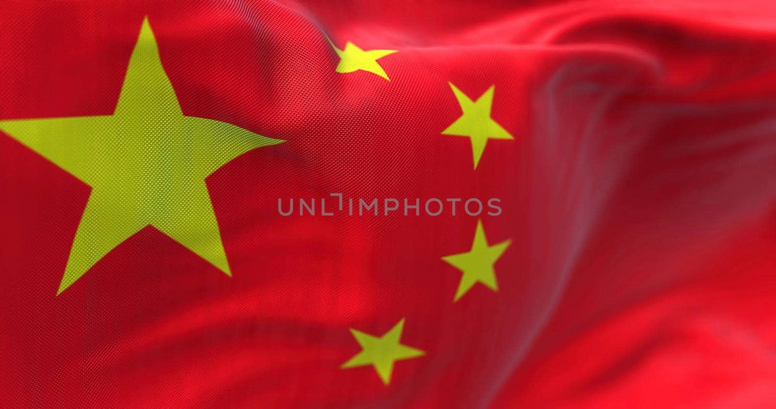 Close-up view of the Chinese national flag waving in the wind. China is a country in East Asia