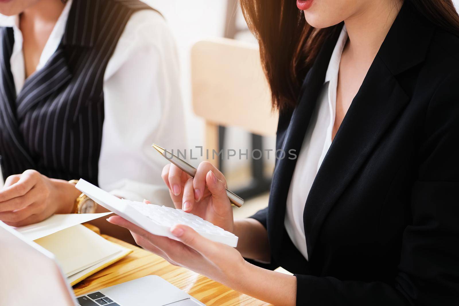 woman working with finance calculate on calculator and using computer laptop and document data chart in office room.