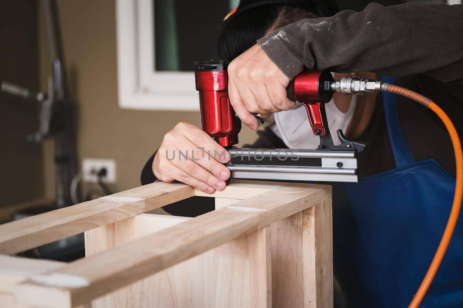 Entrepreneur Woodwork holding a Tacker to assemble the wood pieces as the customer ordered