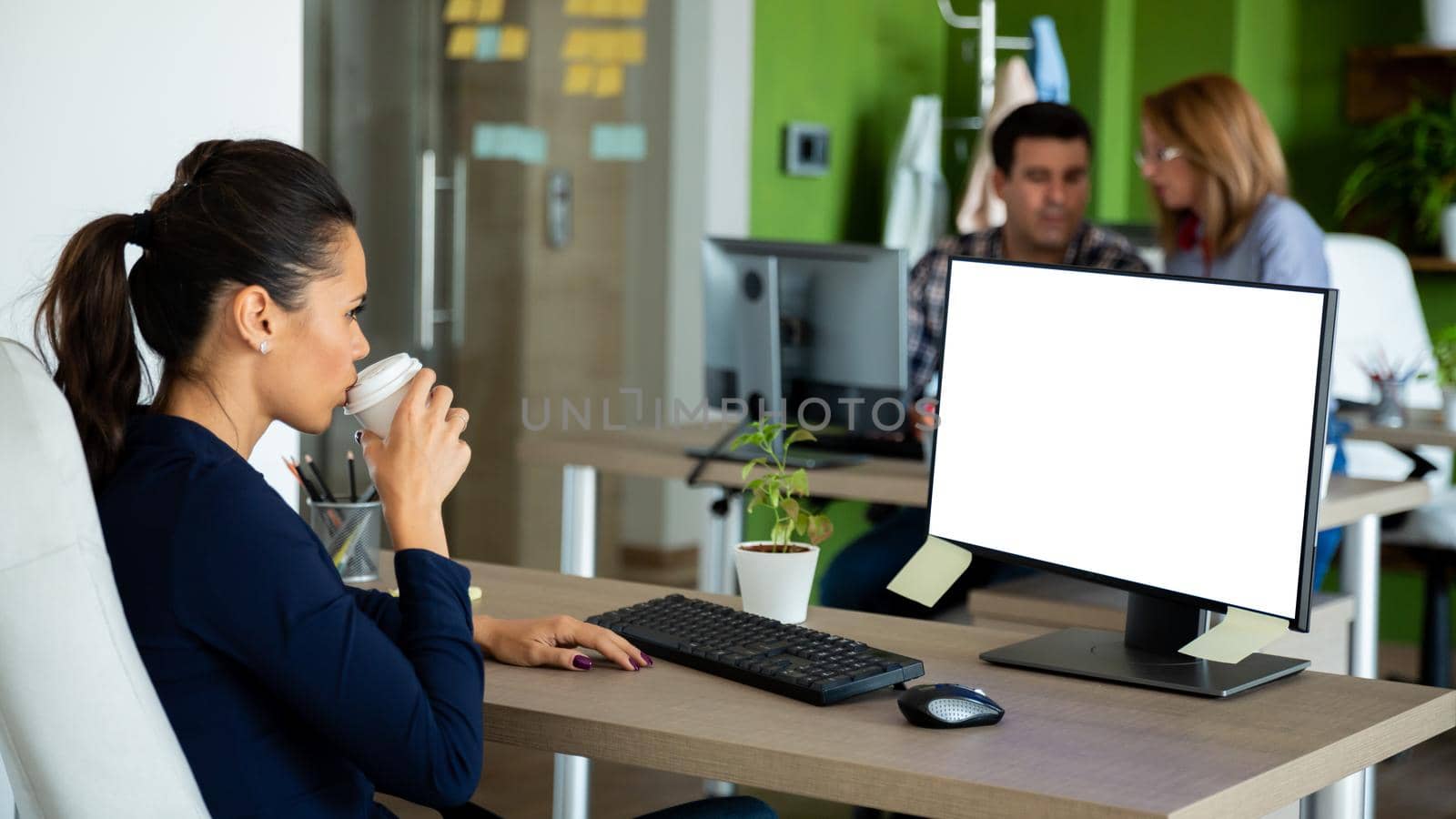 Beautiful businesswoman drink coffee looking at isolated computer screen.Start-up cozy office