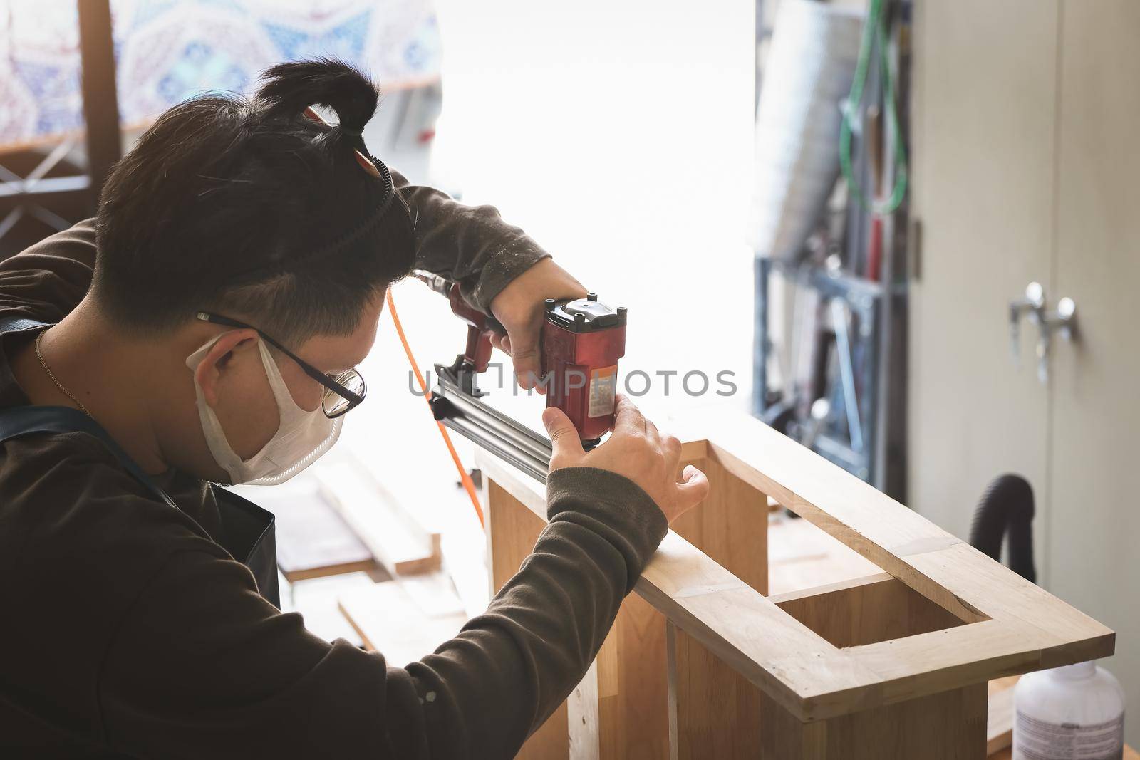 Entrepreneur Woodwork holding a Tacker to assemble the wood pieces as the customer ordered