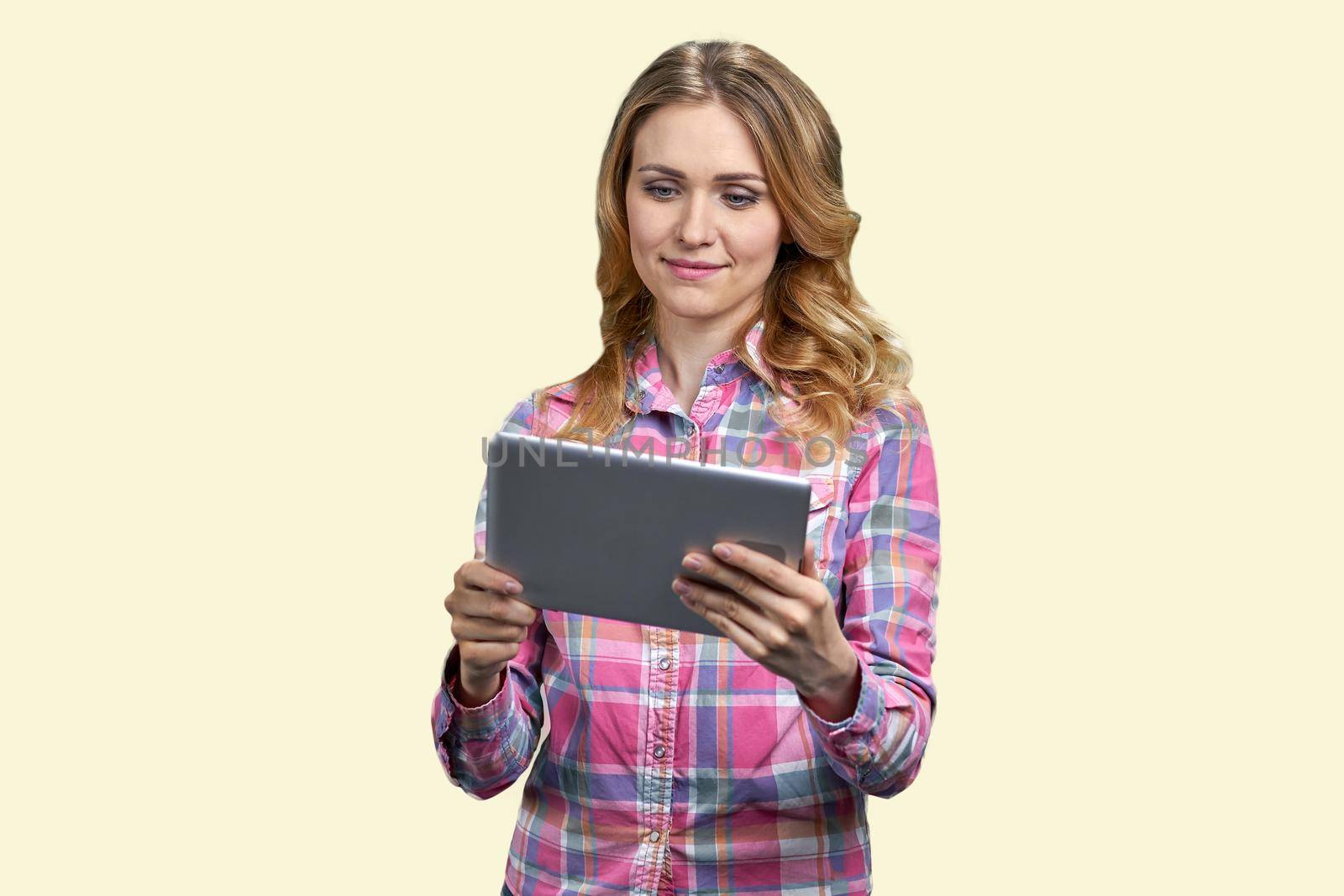 Young smiling woman looking at tablet pc. Isolated on white background. Pretty girl having video call.