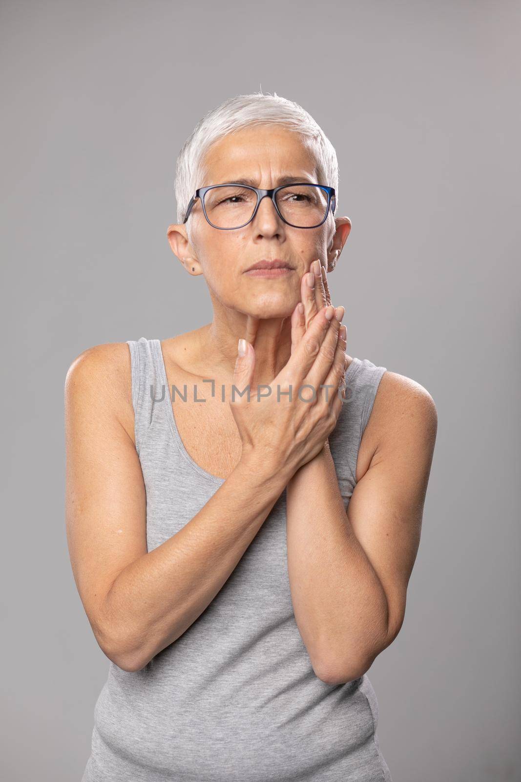 Toothache. pain tooth in mouth, old woman with short gray hair and tootache problems, healthcare and medicine concept