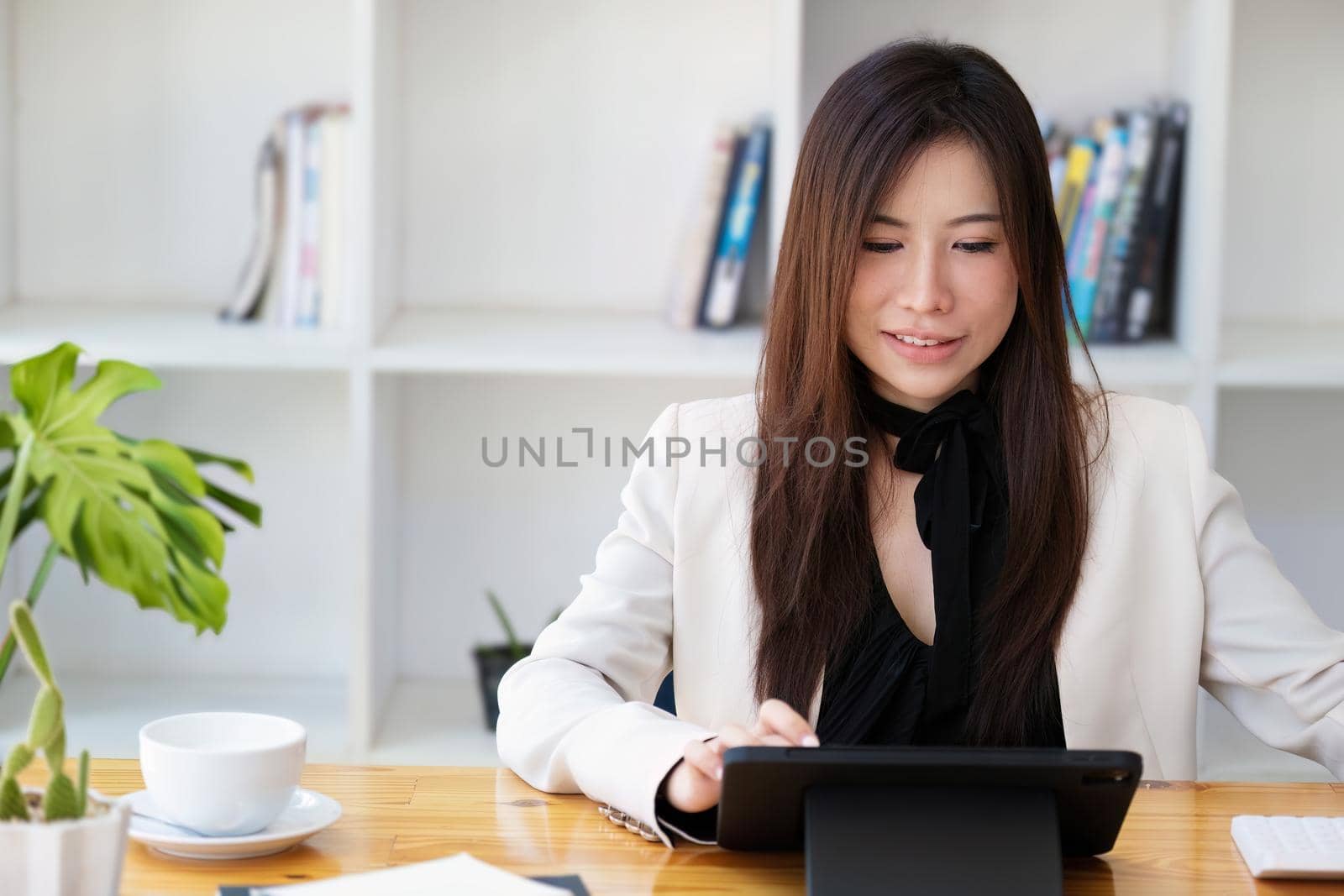 Portrait of a business woman using a tablet computer for data analysis, marketing, accounting by Manastrong