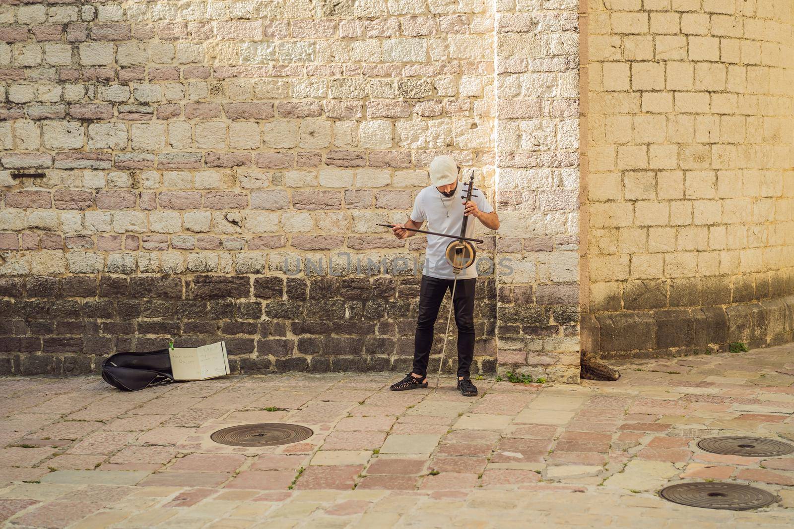 Montenegro Kotor May 27, 2022, the boy plays a musical instrument on the street, editorial.