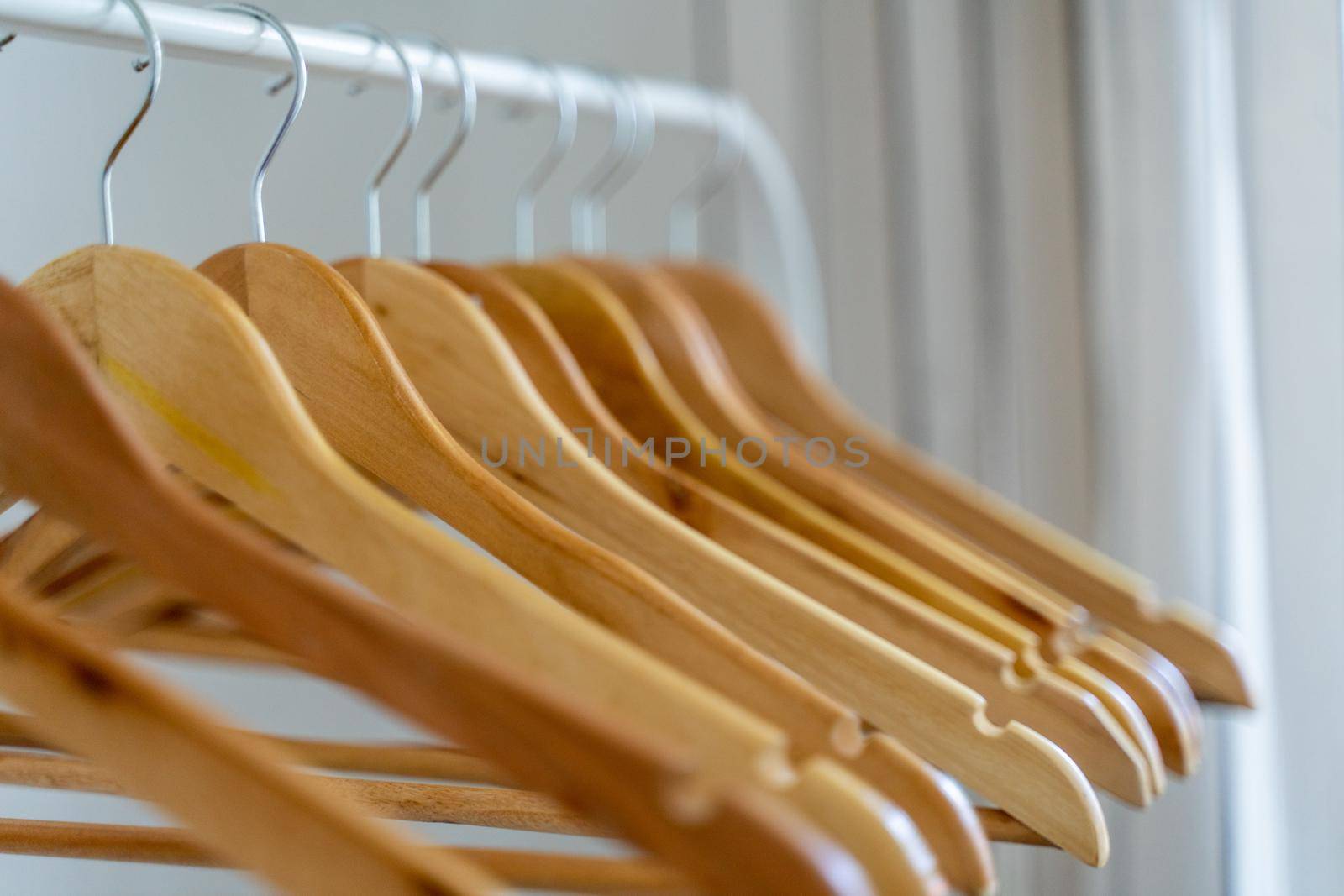 Close-up of wardrobe with wooden clothes hanger, by Matiunina