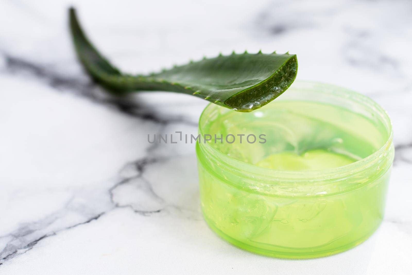 Aloe leaf and gel on a marble background with copy space. Moisturizing, recovery and caring for the skin