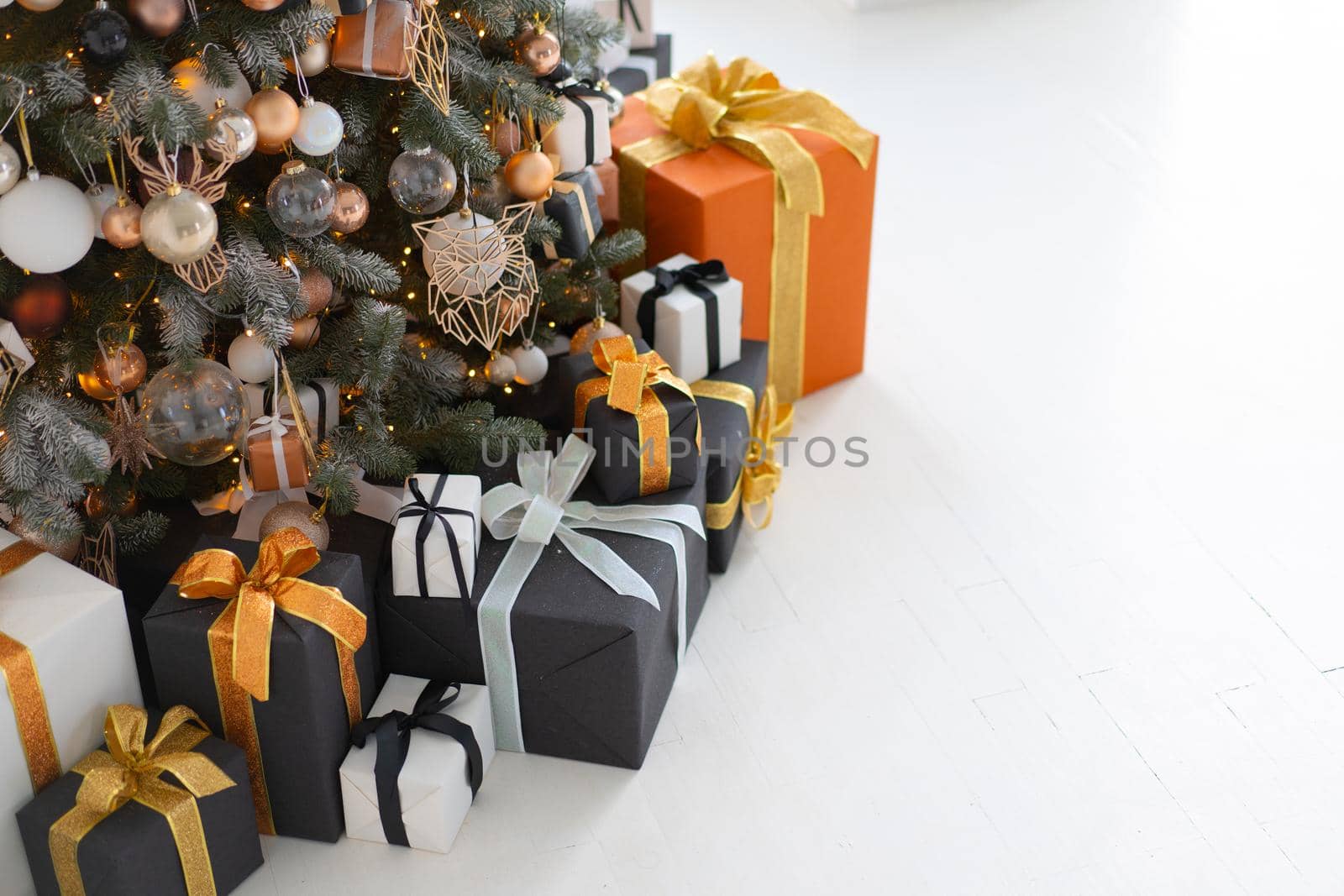 Christmas present box black, orange and white color on white floor with copy space by andreonegin