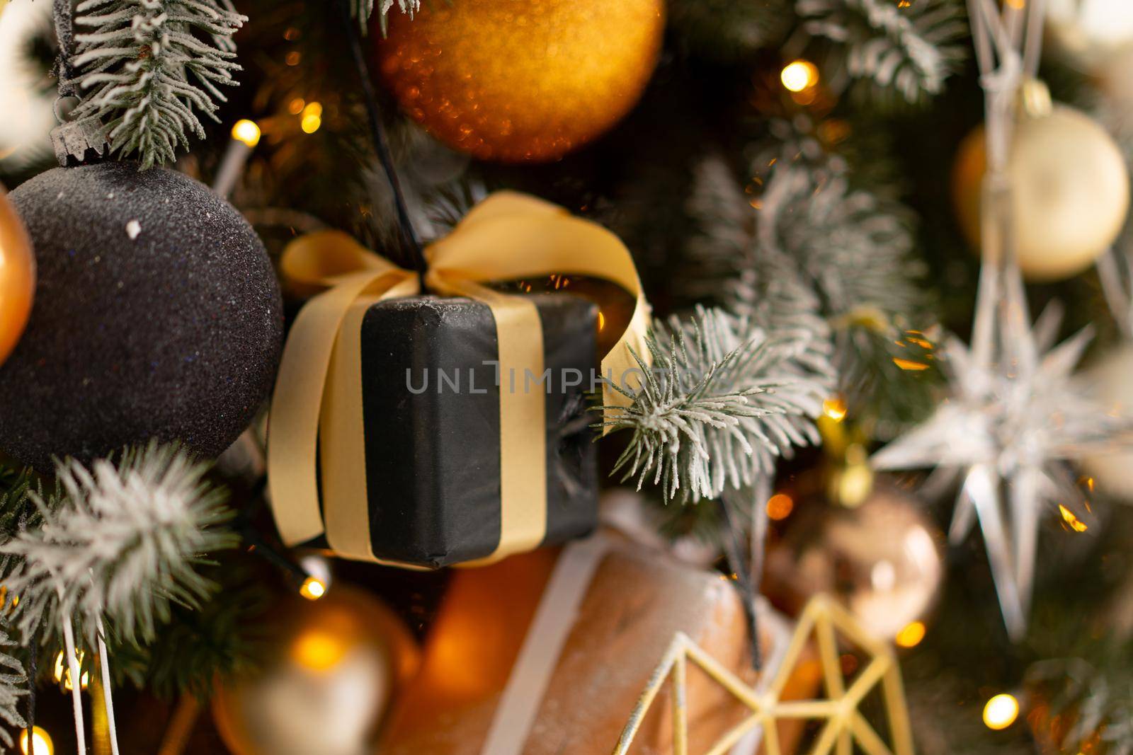 Christmas present gift box stacked close up. Holiday sale concept. Many gift box black, white, orange color with gold ribbon and light garland