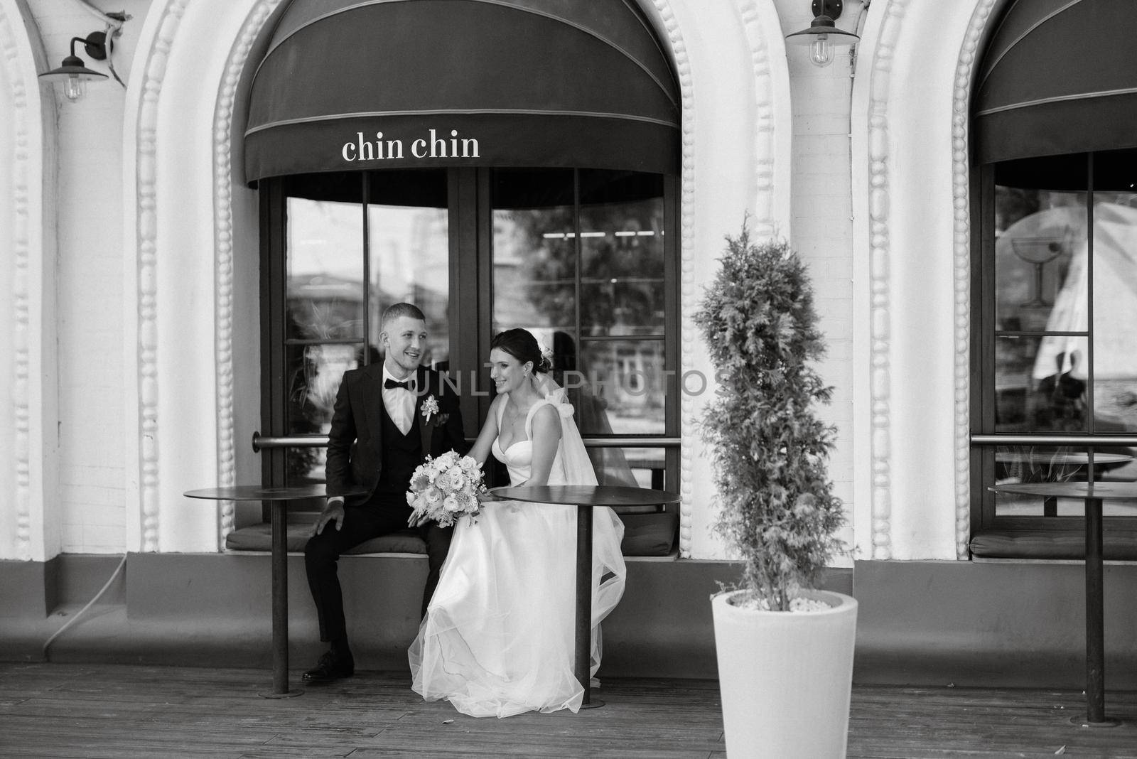 bride and groom near the cafe on the street of the summer city