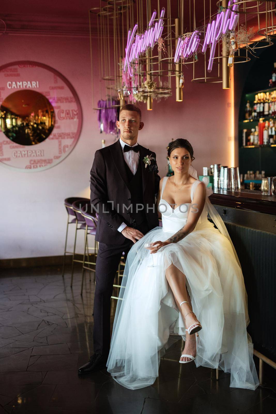 bride and groom inside a cocktail bar in a vibrant atmosphere