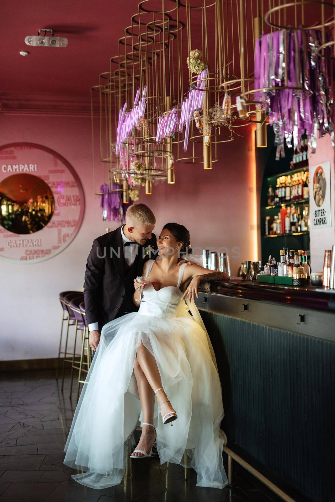 bride and groom inside a cocktail bar in a vibrant atmosphere