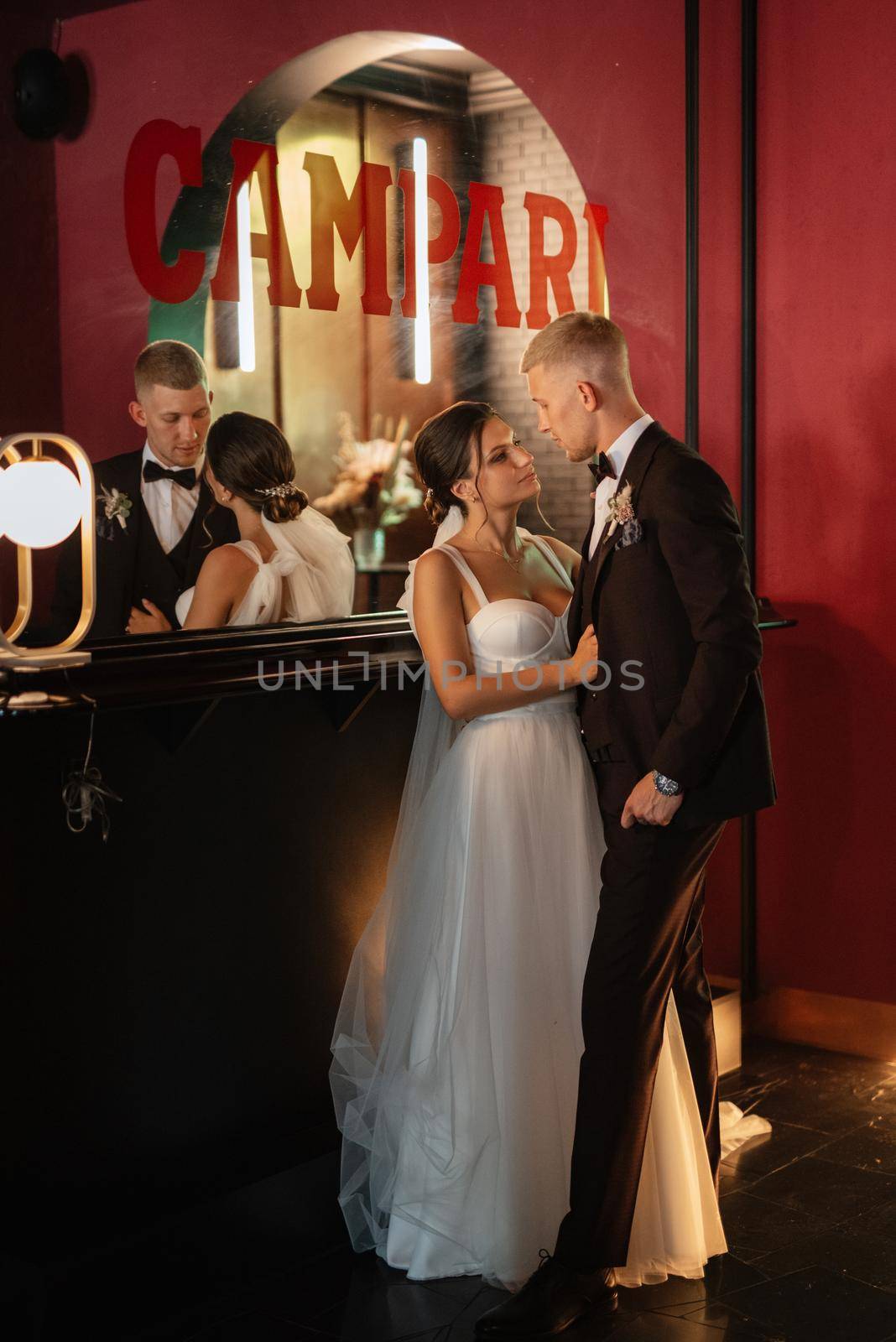 bride and groom inside a cocktail bar in a vibrant atmosphere