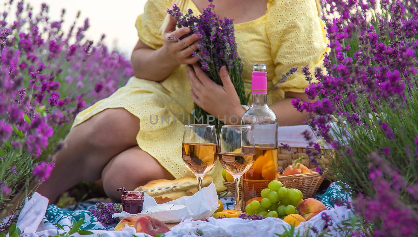 A woman drinks wine in a lavender field. Selective focus. Food.