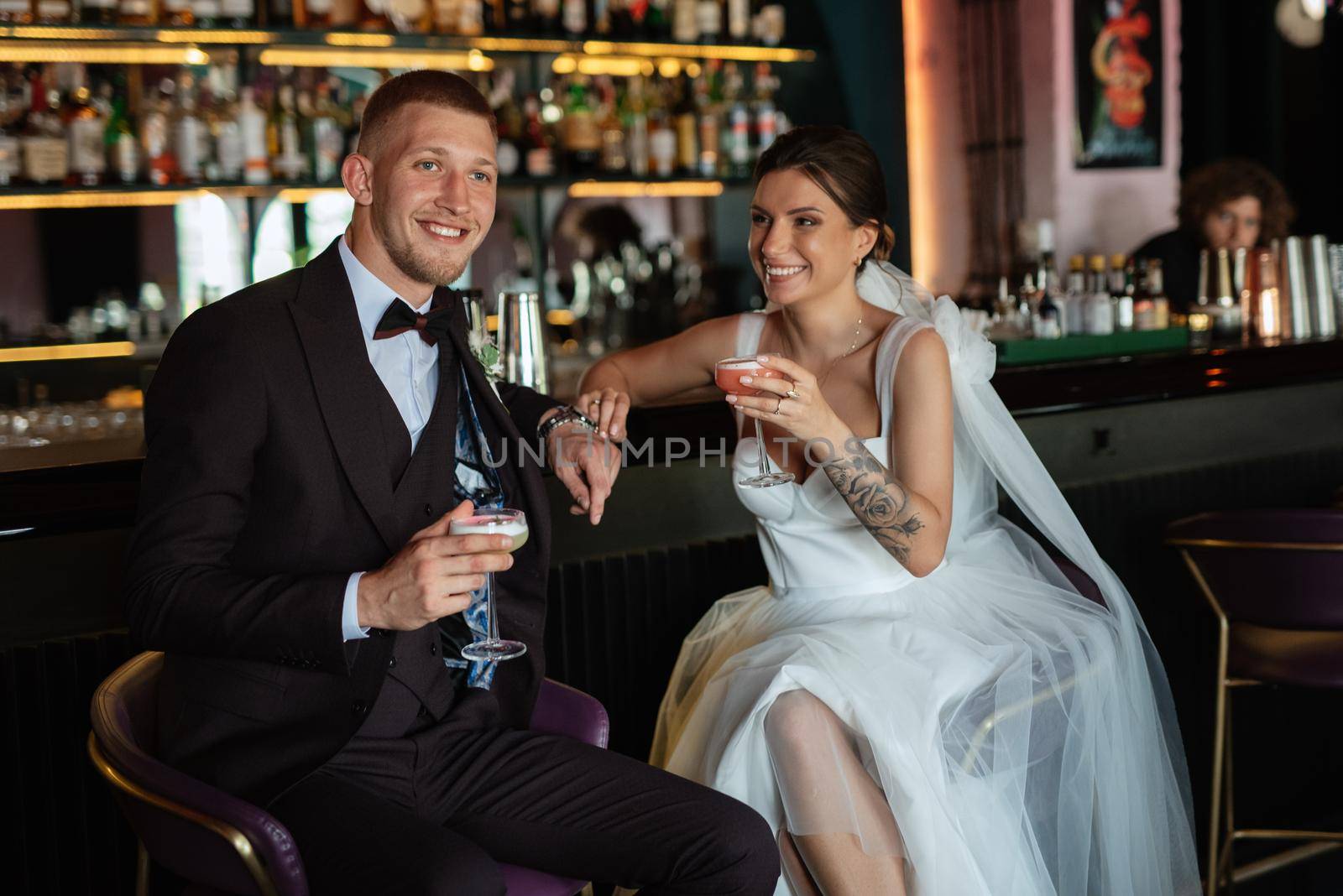 bride and groom inside a cocktail bar in a vibrant atmosphere