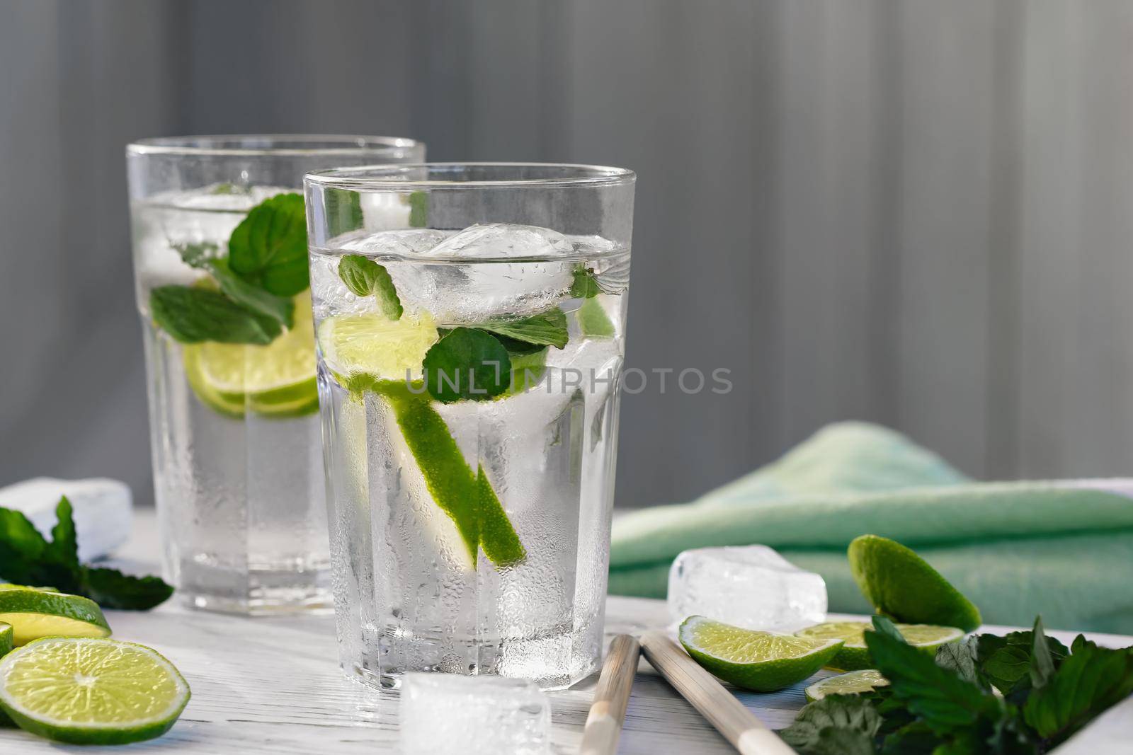 Summer refreshing mojito cocktails with lime and mint on a white wooden tray by galsand