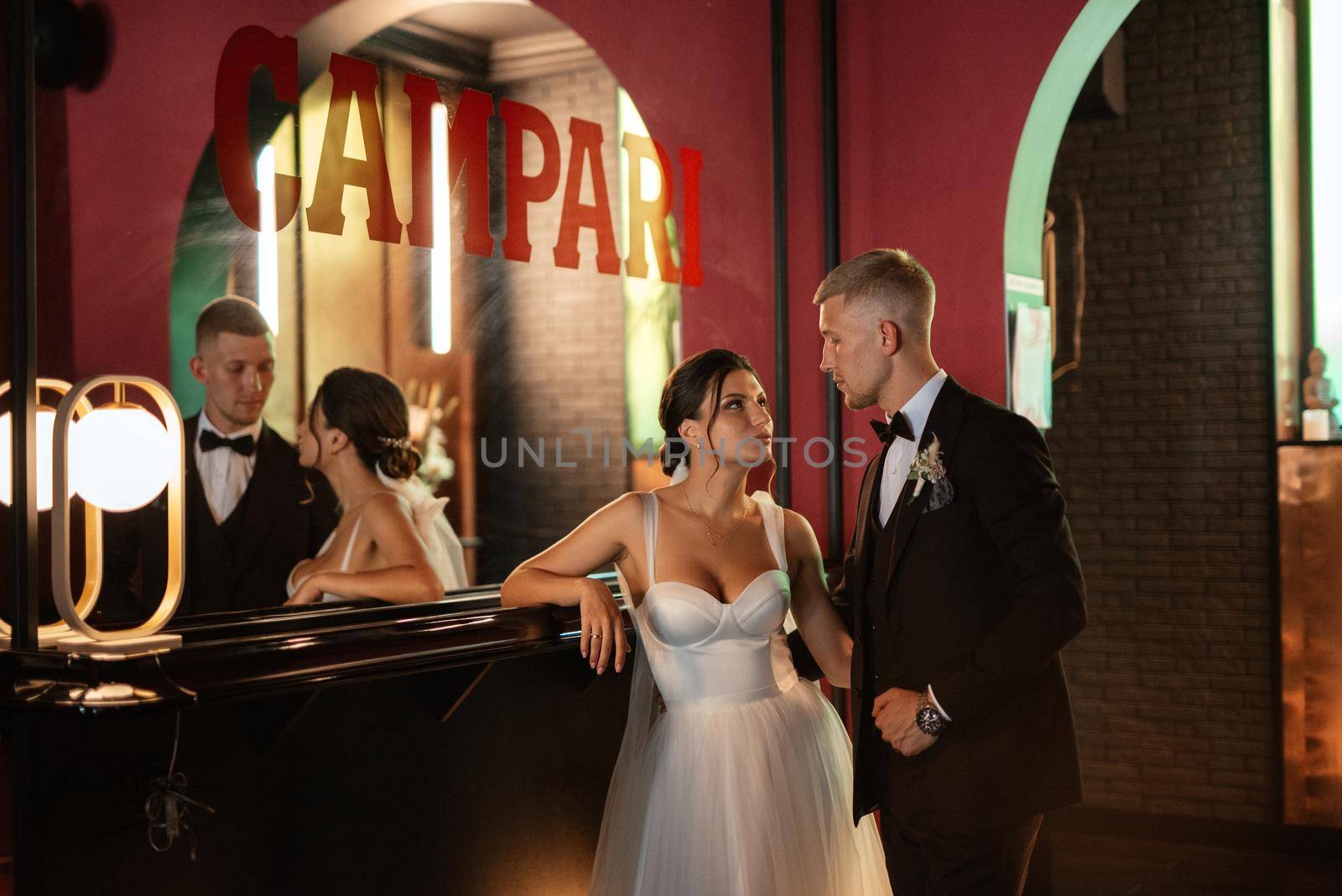 bride and groom inside a cocktail bar in a vibrant atmosphere