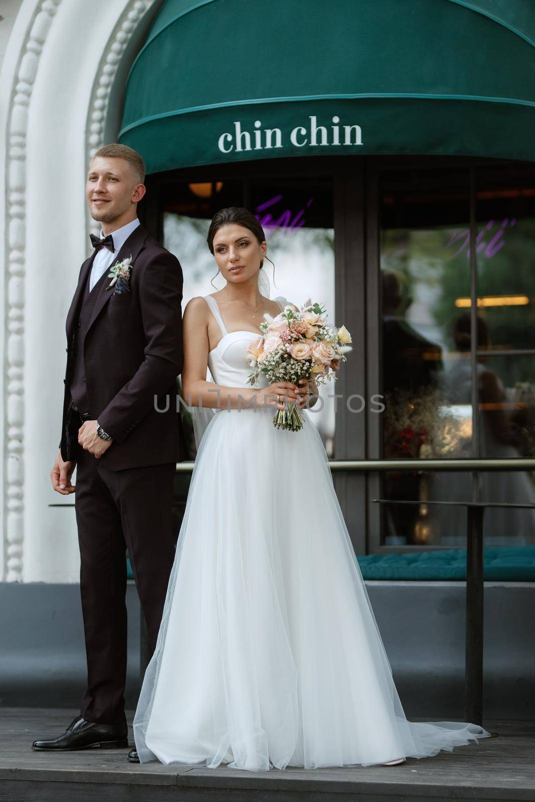 bride and groom near the cafe on the street of the summer city