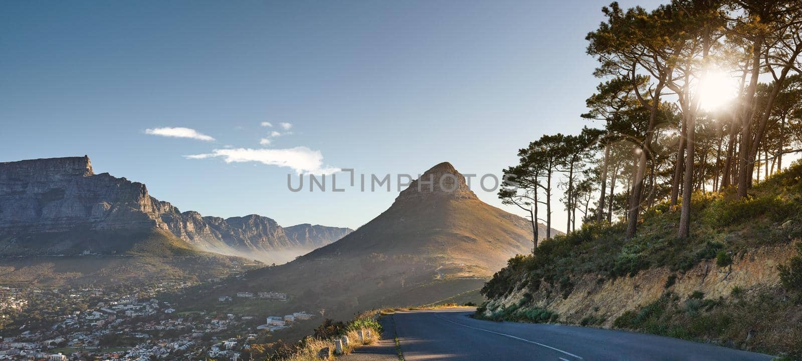 Empty road on the mountain at sunrise. Empty street overlooking mountain peak. Scenic view of the city from a street on the mountain at sunset. Landscape of a beautiful view of a city from a street by YuriArcurs