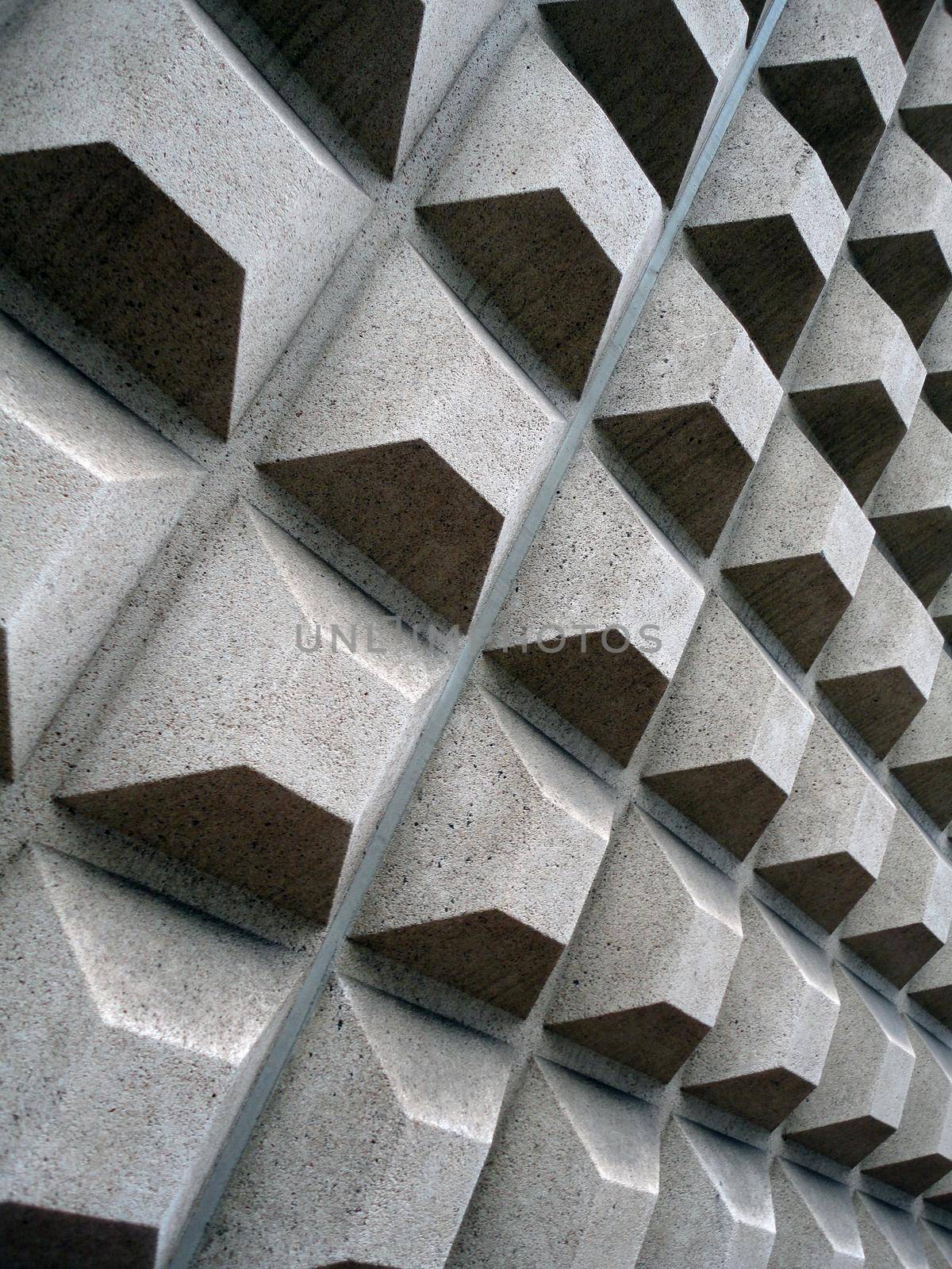 Grey Square concret shapes project out of side wall of building.