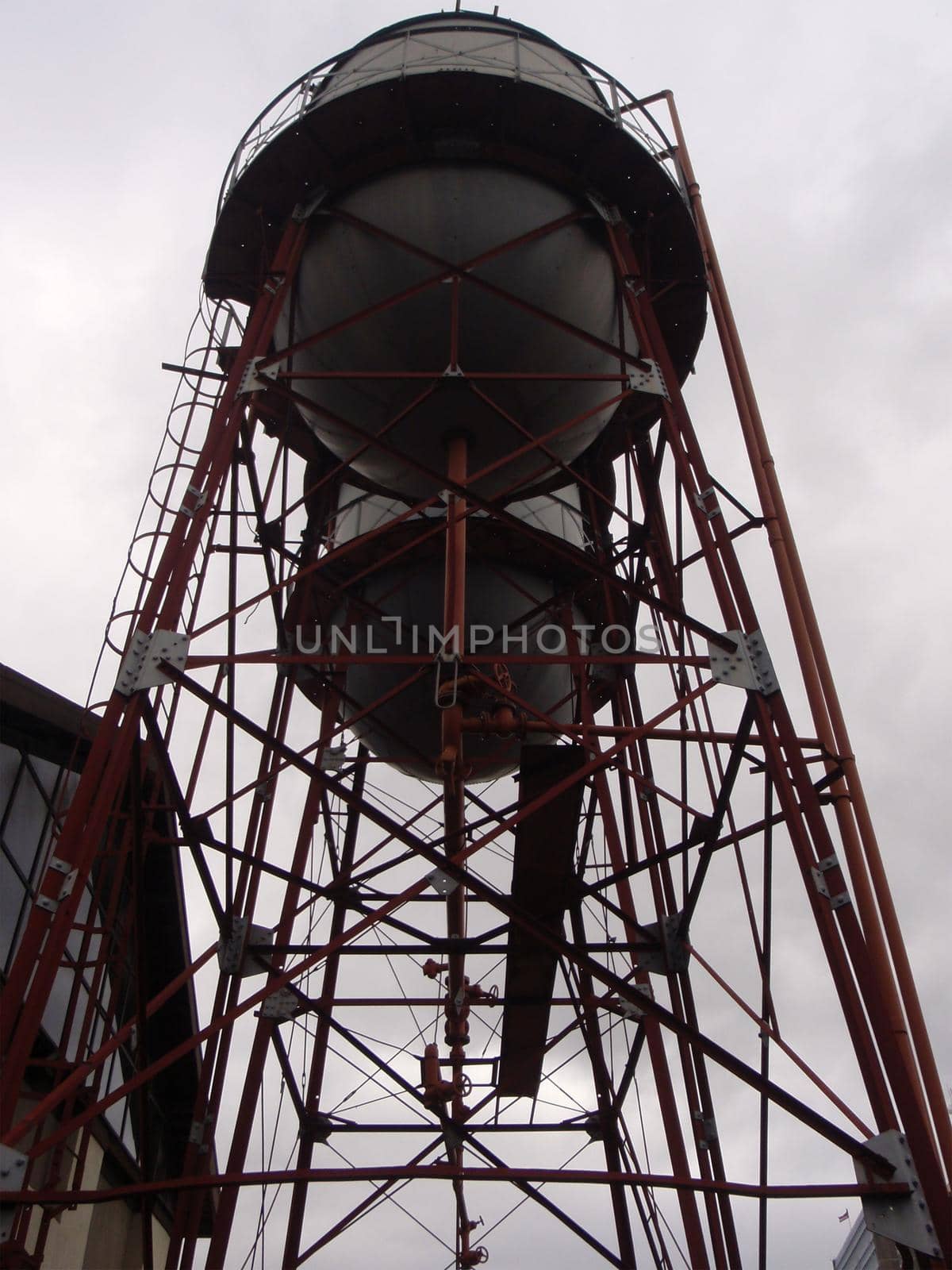 Two water towers with red steel frames against a dark sky in San Jose, Costa Rica