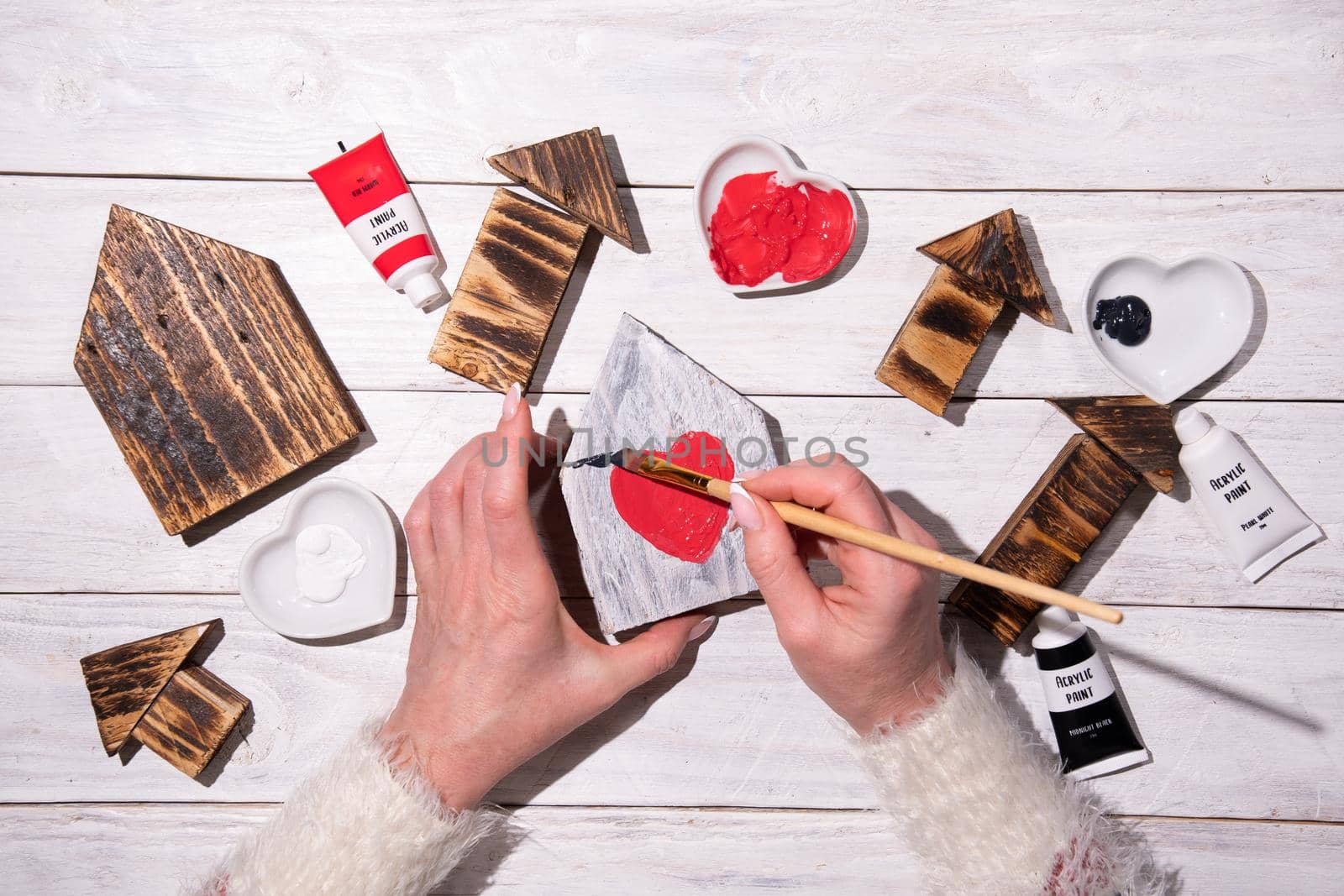 female hands draw a heart on a wooden house, crafting, step by step instructions how to make decor for valentine's or mother's day, Sweet Home. High quality photo
