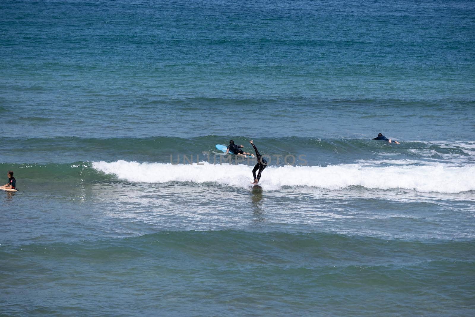 Guipuzkoa, Zarautz, Spain - 09, July, 2022: Group of surfers on the beaches of Zarautz. by barcielaphoto